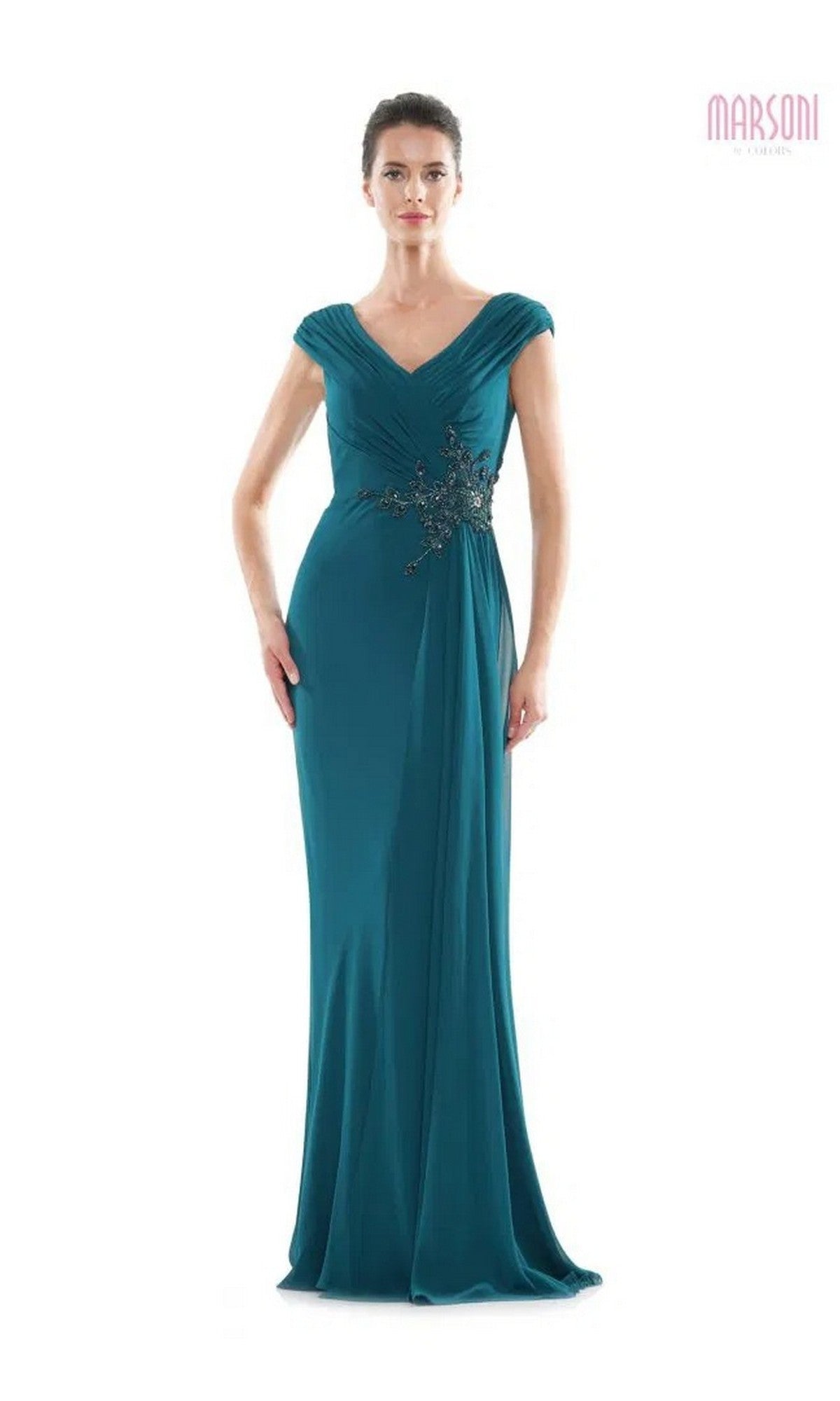 A woman wearing the Marsoni MV1080 Long Formal Dress in deep green, featuring short sleeves, a pleated neckline, and beaded applique at the waist, stands against a plain white background.